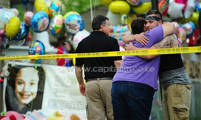 Friends and relatives stand in front of the DeJesus family home as it stands decorated by well wishers on May 7 in Cleveland. Picture/AFP