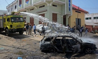 A water cannon is used to douse a car after an IED was detonated in Mogadishu's Bakara market on June 9, 2013/AFP