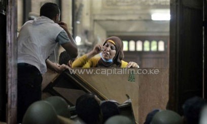 An Egyptian woman talks to policemen from the inside of Cairo's Al-Fath mosque where Islamist supporters of ousted president Mohamed Morsi held up on August 17, 2013/AFP