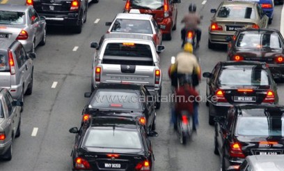 Motorcyclists ride in-between lanes to beat congestion during lunch-hour traffic in downtown Kuala Lumpur/AFP