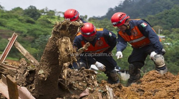 Mexican Federal Police search for bodies on the site of a landslide in La Pintada, Guerrero state, on September 19, 2013/AFP