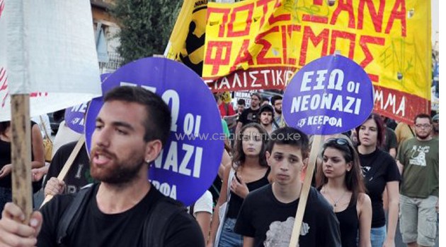 Anti-fascist protesters hold signs reading 'Fascism never again' at a rally in Athens on September 18, 2013/AFP