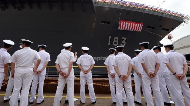 Crew members of Japan's warship, the DDH183 Izumo, stand alongside the vessel during a launch ceremony in Yokohama on August 6, 2013/AFP