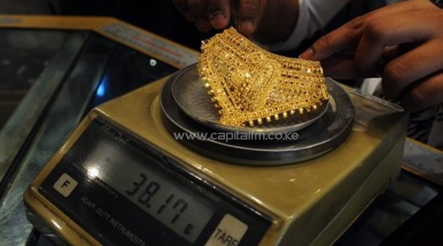 A jeweller weighs a gold necklace for a customer at a shop in Kolkata on April 11, 2012/AFP