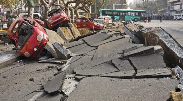 Damaged vehicles lie in the street after an oil pipeline exploded, ripping roads apart, turning cars over and sending thick black smoke billowing over the city of Qingdao, eastern China's Shandong province on November 22, 2013/AFP