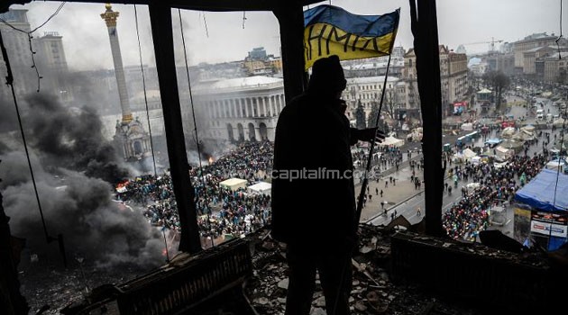 A demonstrator stands on a balcony overlooking Independence square during a face off against heavily-armed police on February 20, 2014 in Kiev © AFP