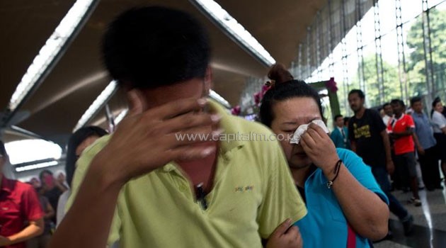 A woman (R) breaks down while leaving the reception centre for families and friends of passengers on a missing Malaysia Airlines jet at the Kuala Lumpur International Airport on March 8, 2014 © AFP