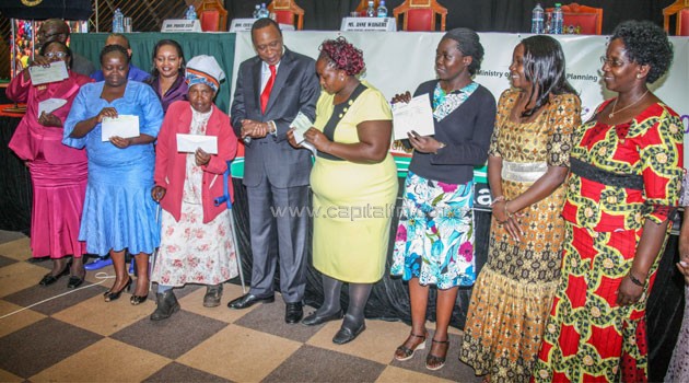 President Kenyatta presenting cheques to groups that benefited from Women Enterprise Fund. Photo/PSCU