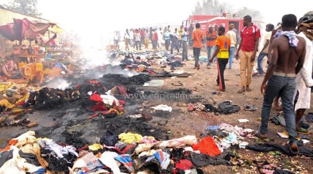 Rescuers and residents gather at the charred scene following a bomb blast at Terminus market in the central city of Jos on May 20, 2014/AFP