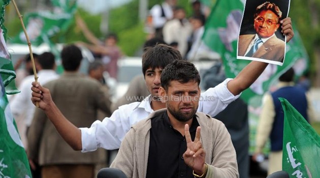 Supporters of Pakistan's former military ruler Pervez Musharraf hold his photograph during a rally outside his house in Islamabad on April 18, 2014/AFP