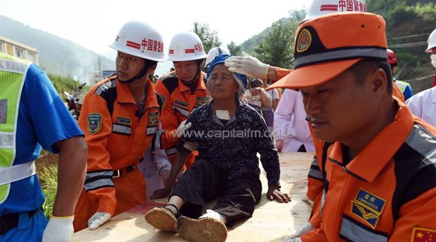 Rescue personnel carry an injured elderly earthquake survivor on a plank of wood, to a helicopter in Longtoushan, China's southwest Yunnan province, on August 6, 2014/AFP