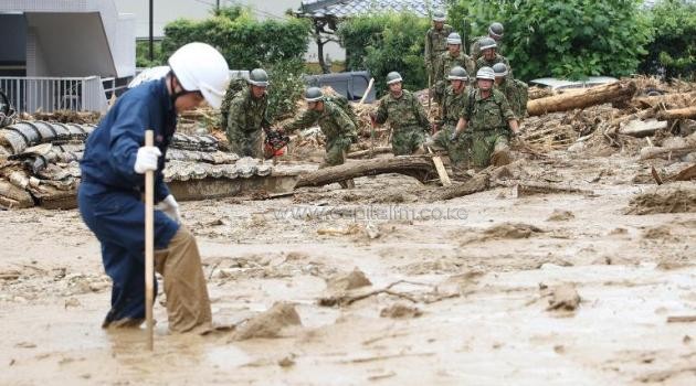 Soldiers and rescue workers look for survivors at the site of a landslide after heavy rains hit the city of Hiroshima, western Japan, on August 20, 2014/AFP
