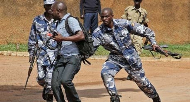 Police arrest a journalist outside the Daily Monitor offices, in Kampala/AFP