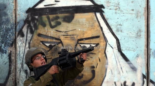 A member of the Israeli security forces aims a tear gas launcher during clashes with Palestinian protestors following a rally on November 2, 2014 at the Qalandia checkpoint, between Ramallah and Jerusalem City/AFP