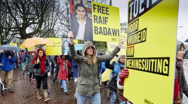 People take part in a protest by Amnesty International for the release of Saudi blogger Raif Badawi, outside the Saudi Embassy in The Hague, on January 15, 2015/AFP