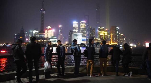 People look at the view from Shanghai's waterfront Bund, near the site of the New Year's Eve stampede on January 2, 2015/AFP