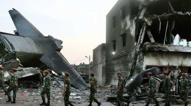 Search and rescue personnel at the crash site of an Indonesian Air force C-130 Hercules aircraft in Medan, northern Sumatra province, on July 1, 2015/AFP