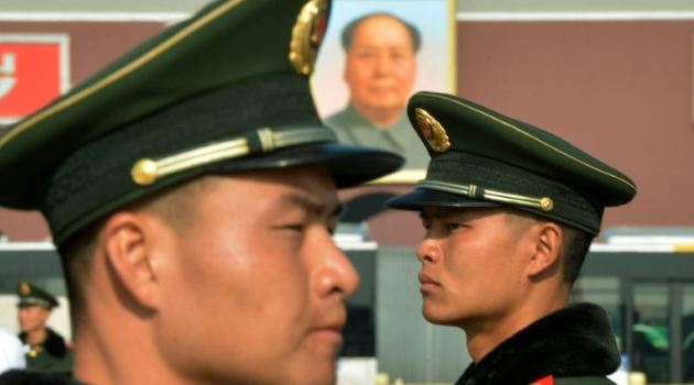 Chinese paramilitary police stand guard in front of the portrait of late leader Mao Zedong at Tiananmen Square in Beijing on November 6, 2012/AFP