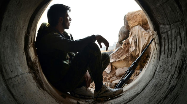 A rebel fighter rests during clashes with pro-government forces on the outskirts of the central Syrian province of Homs on October 19, 2015 © AFP