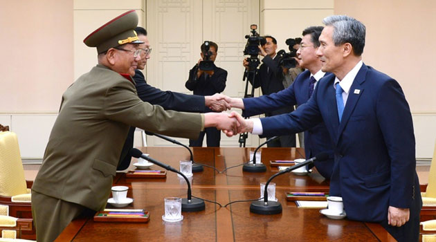Representatives from North Korea (L) and the South shake hands as they meet at the truce village of Panmunjom, in August 2015 © S.Korean Unification Ministry/AFP/File