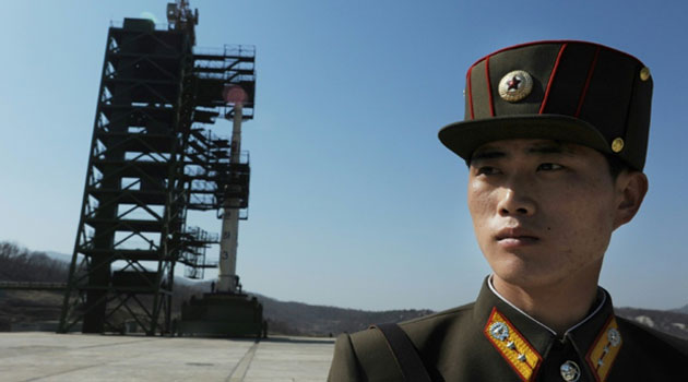 A North Korean soldier stands guard in front of an Unha-3 rocket at the Sohae Satellite Launch Station in Tongchang-Ri on April 8, 2012 © AFP/File