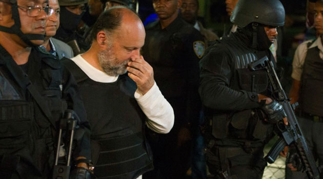 Frenchman Christophe Naudin (C) is escorted by police on arrival in Santo Domingo, Dominican Republic after being extradited by Egypt © AFP