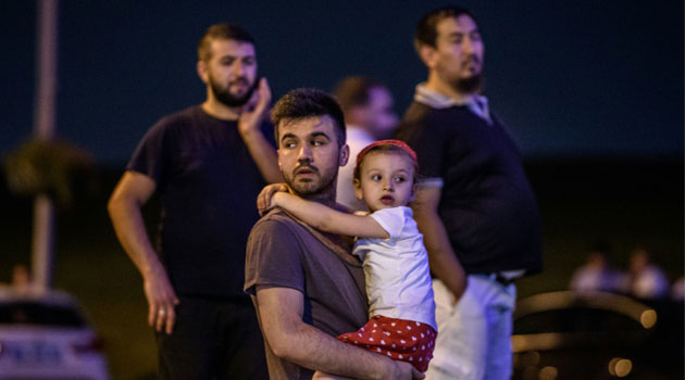 A man carries his daughter outside as people leave the airport after two explosions followed by gunfire hit the Turkey's biggest airport of Ataturk in Istanbul, on June 28, 2016/AFP