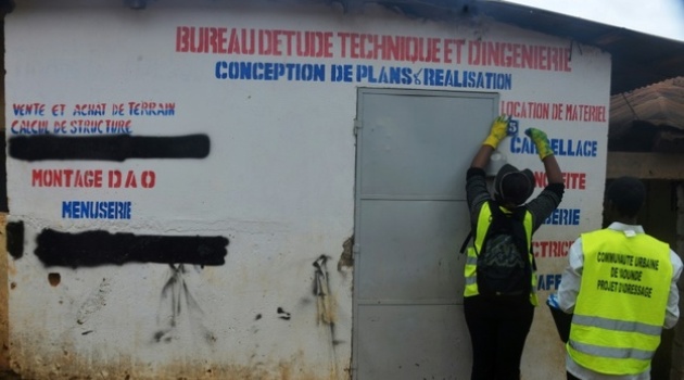 A painter applies numbers to houses in Yaounde, Cameroon, where getting around a city with few street names and no numbers a firm grasp of local landmarks/AFP
