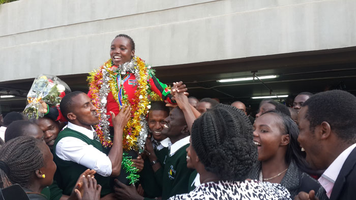 Girls' 2000m steeplechase champion, Celliphine Chepteek, is received by fellow Nairobi Riruta Satellite Secondary School students. PHOTO/Courtesy