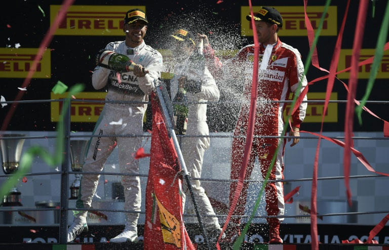 Mercedes driver Lewis Hamilton (L) celebrates with Ferrari's Sebastian Vettel (R) and Williams Martini Racing's Felipe Massa after the Italian Formula One Grand Prix at the Autodromo Nazionale circuit in Monza on September 6, 2015. PHOTO/AFP