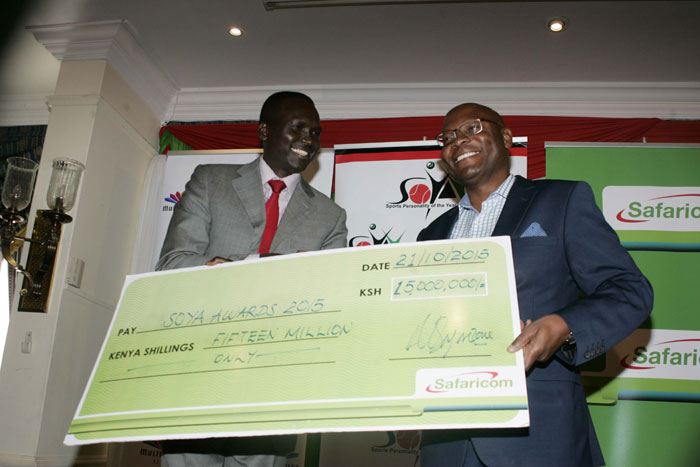 Paul Tergat (left) receives Sh15m sponsorship dummy cheque from Safaricom head of Communications, Joseph Ogutu towards the 2015 SOYA Awards on October 21, 2015. PHOTO/Raymond Makhaya