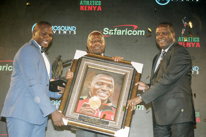 Julius Yego (left) receives a portrait of self from Sports Cabinet Secretary, Dr. Hassan Wario at the 2015 AK Gala Awards on December 10, 2015. PHOTO/AFP