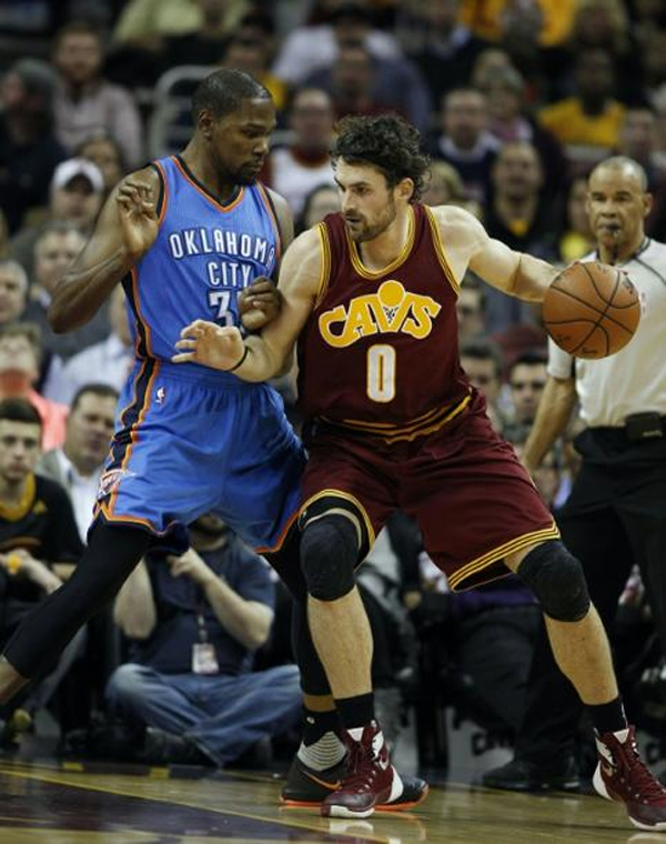 Oklahoma City Thunder's Kevin Durant (L) defends against Kevin Love of the Cleveland Cavaliers during the first half of their game on December 17, 2015 at Quicken Loans Arena