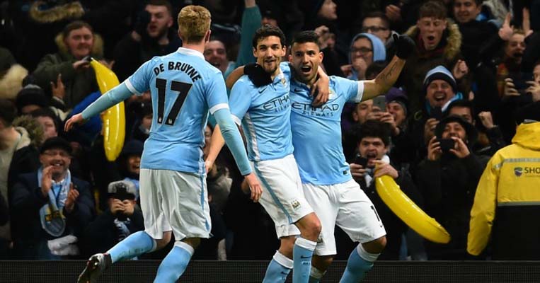 MANCHESTER, ENGLAND - JANUARY 27: (R-L) Sergio Aguero of Manchester City is congratulated by teammates David Silva and Kevin De Bruyne of Manchester City after scoring his team's third goal during the Capital One Cup Semi Final, second leg match between Manchester City and Everton at the Etihad Stadium on January 27, 2016 in Manchester, England. PHOTO/Team Talk