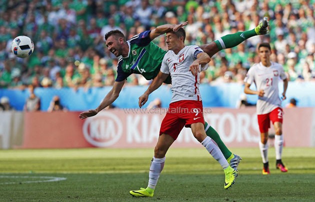 McAuley (left) is felled by Bayern Munich and Poland striker Robert Lewandowski as the pair challenge for an aerial ball in the first half-PHOTO/DAILYMAIL