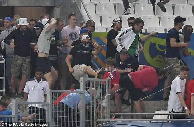 A Russian fan wearing a balaclava rushes towards an England supporter as violence kicked off at full-time.PHOTO/courtesy.