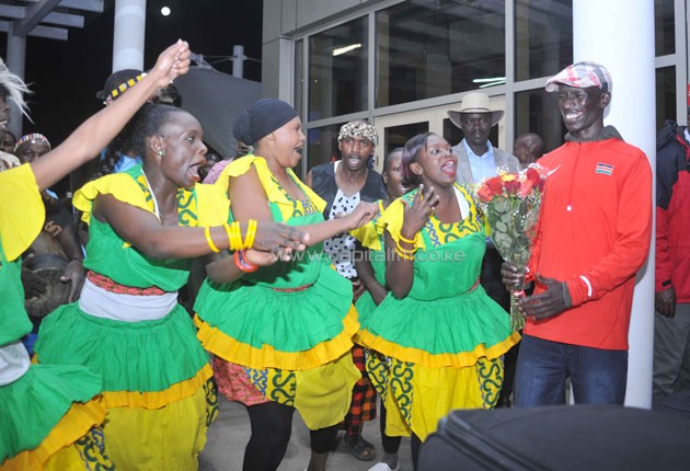Ezekiel Kemboi enjoys a jig with traditional dancers at the Jomo Kenyatta Airport upon arrival. PHOTO/RAYMOND MAKHAYA