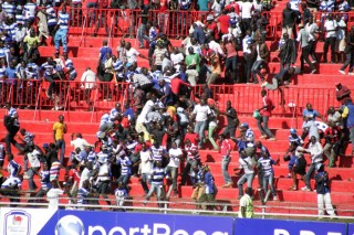 AFC Leopards fans flee tear gas during Sunday's Mashemeji Derby. PHOTO/Raymond Makhaya