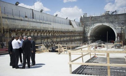 Barack Obama speaks with officials as he tours the Port Miami tunnel project in Miami, Florida on March 29, 2013/AFP