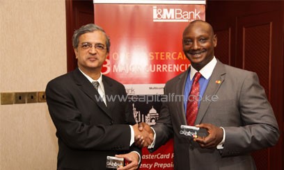 Left: I&M Bank CEO, Arun Mathur and MasterCard Vice-President and Area Business Head, East Africa James Wainaina shake hands and show off the new I&M Bank MasterCard Multicurrency Prepaid Card at the launch event/COURTESY