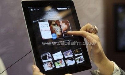 A fair goer tries out the an e-book reader app on an Apple iPad at the Leipzig Book Fair on March 15, 2012/AFP