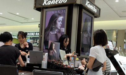An employee of Japanese cosmetics company Kanebo attends to a customer in Tokyo on September 3, 2013/AFP