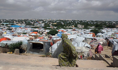 A Somali refugee walks in front of a camp for internally displaced people in Mogadishu December 4, 2012/AFP