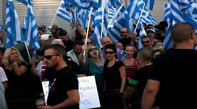 Supporters of extreme far right Golden Dawn party shout out slogans while holding Greek flags during a protest in solidarity with the parties arrested Lawmakers outside the police headquarters on September 28, 2013/AFP