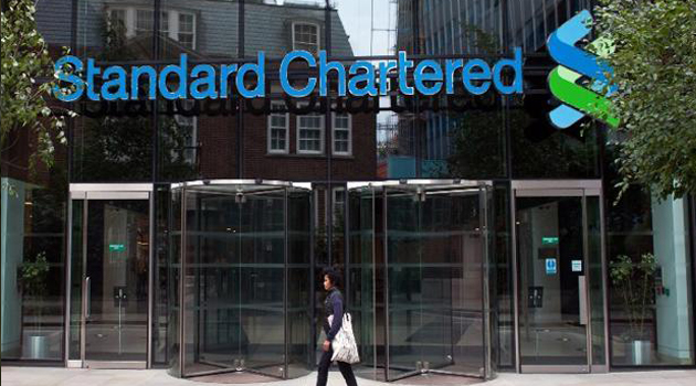 A woman walking past Standard Chartered Bank/AFP