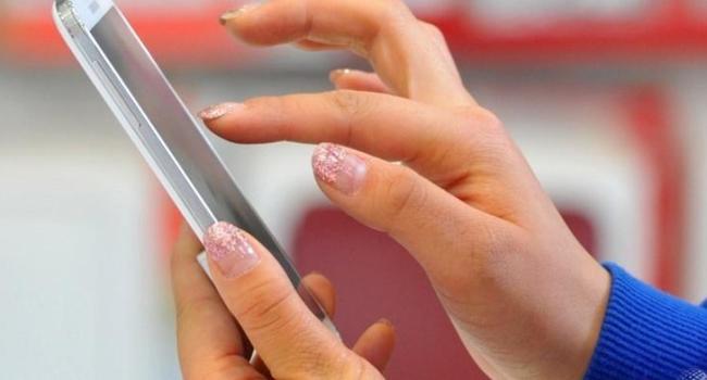 A customer holds a smartphone at a store in Seoul, South Korea/AFP