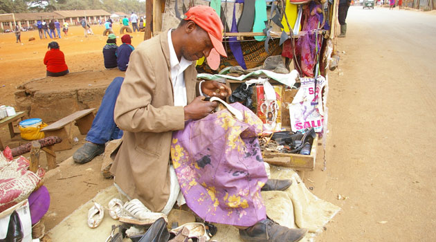A man repairs shoes along the streets of the Thika Super Highway in Nairobi, capital of Kenya/XINHUA-File