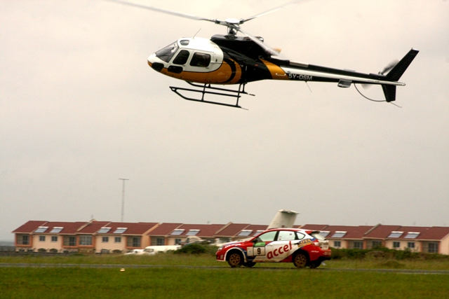 Quentin Mitchell races against a helicopter flown by former rally driver Marco Brighetti during a practice run at the Wilson Airport on Wednesday.