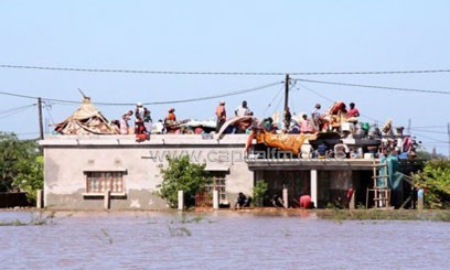 Residents flee to the roof of a house in the Chokwe district of southern Mozambique, to escape flooding on January 25/AFP