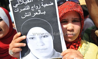 A Moroccan woman carrying a poster/AFP